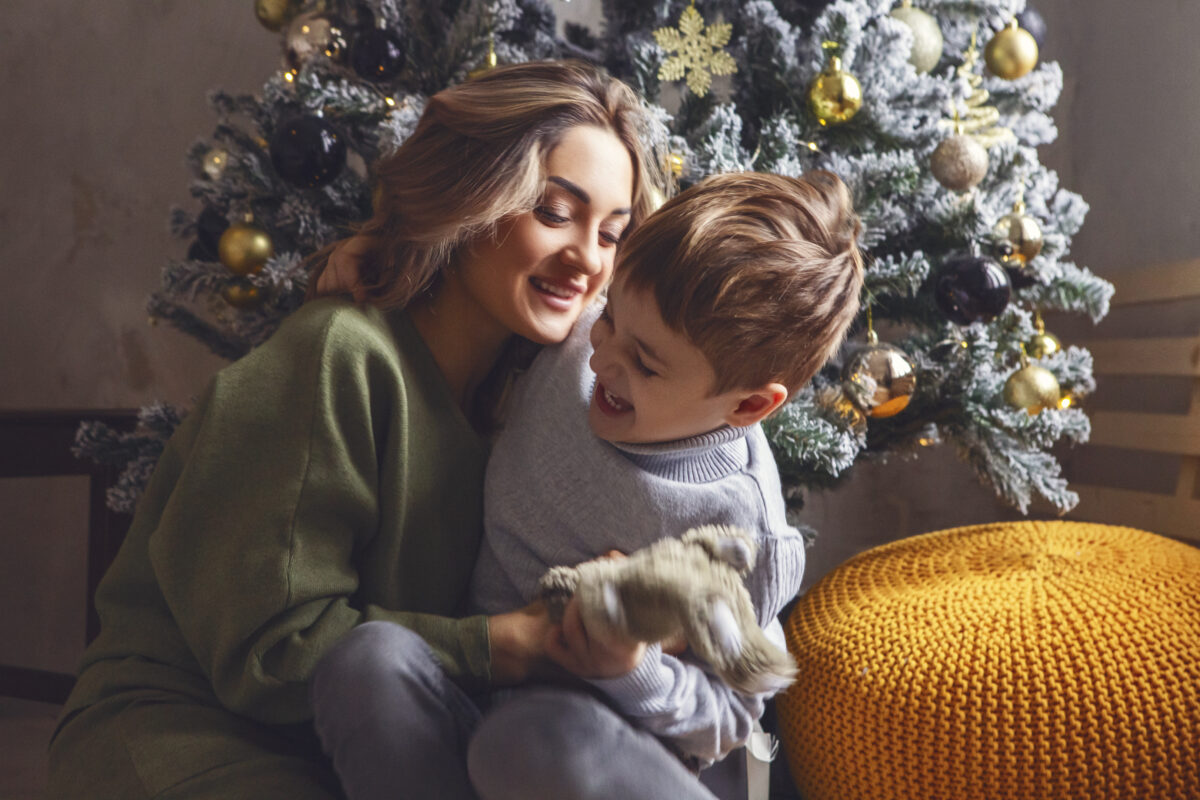 cute little boy unpacking christmas gift with moth 2023 11 27 05 16 10 utc