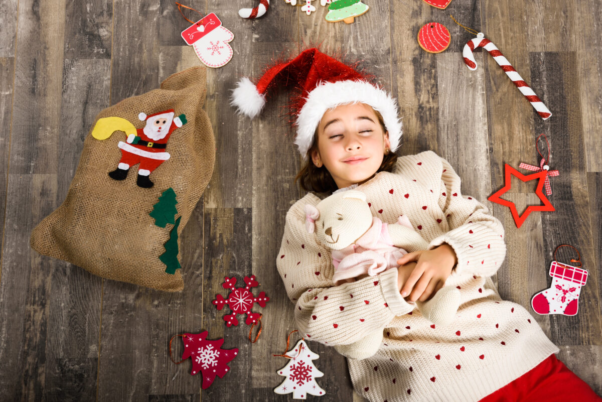 adorable little girl wearing santa hat laying on w 2023 11 27 04 53 37 utc 1